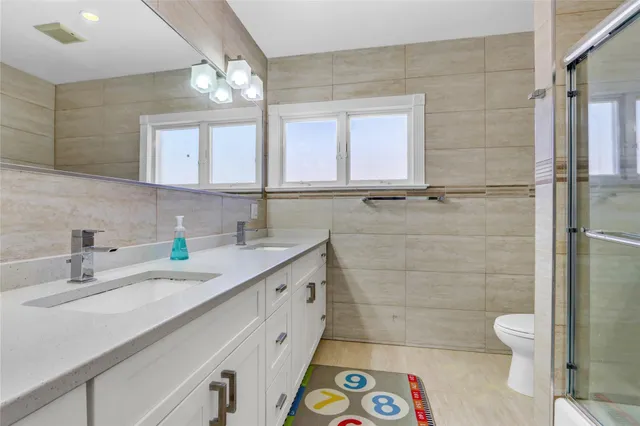 a bathroom with a sink a toilet and a mirror