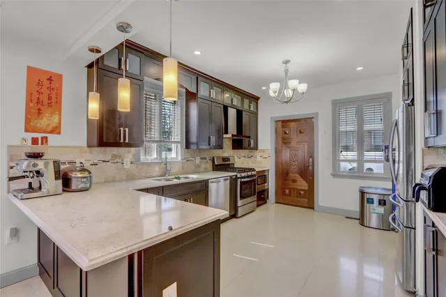 a kitchen with stainless steel appliances a sink stove and refrigerator