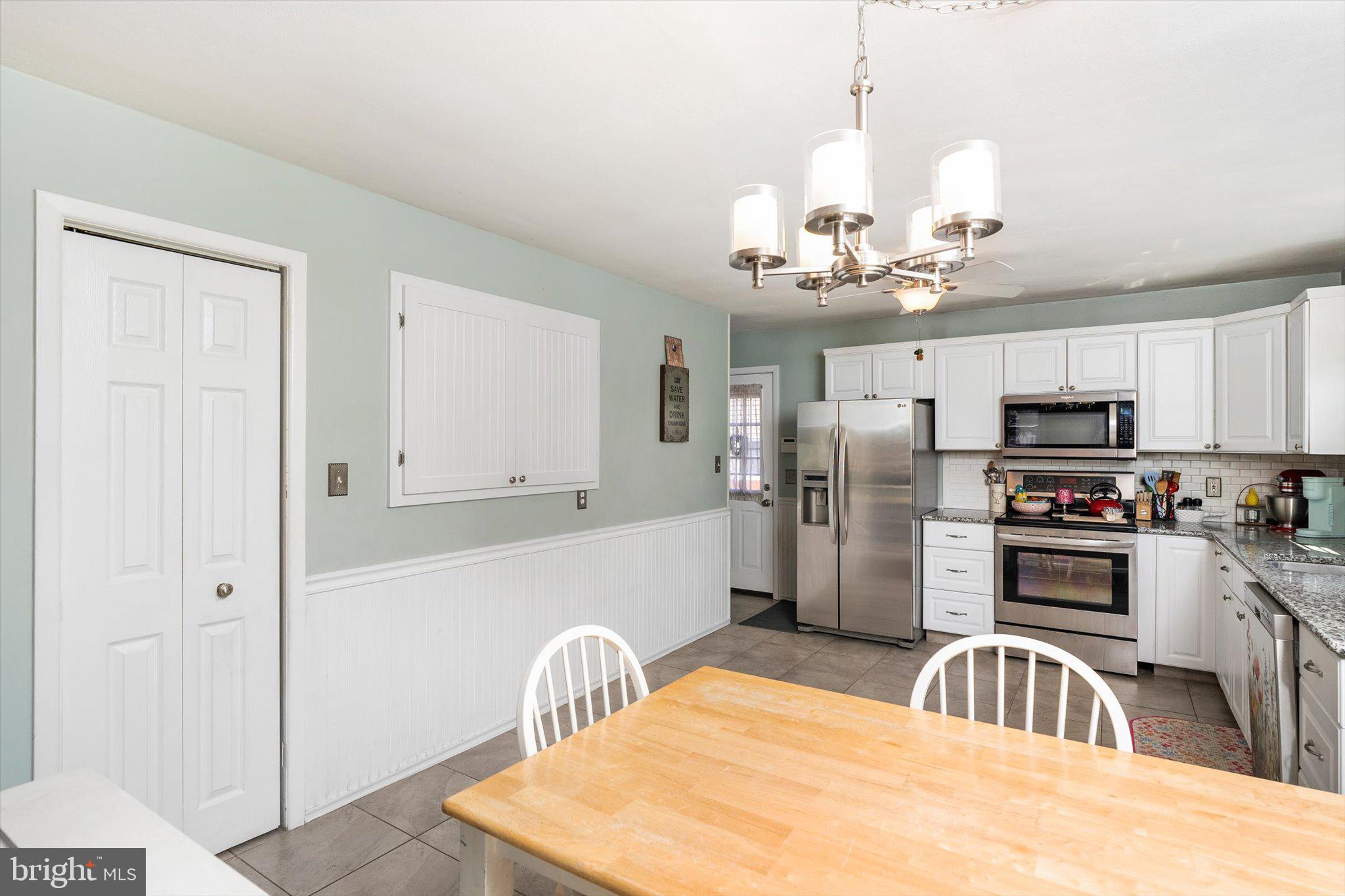 15 Decou Avenue Ewing, NJ 08628 - Photo 12 of 33 a kitchen with stainless steel appliances kitchen island granite countertop a refrigerator a sink dishwasher a oven with white cabinets and wooden floor