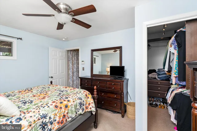 a bedroom with a bed and a flat tv screen on dresser