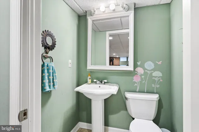 a bathroom with a toilet sink and mirror