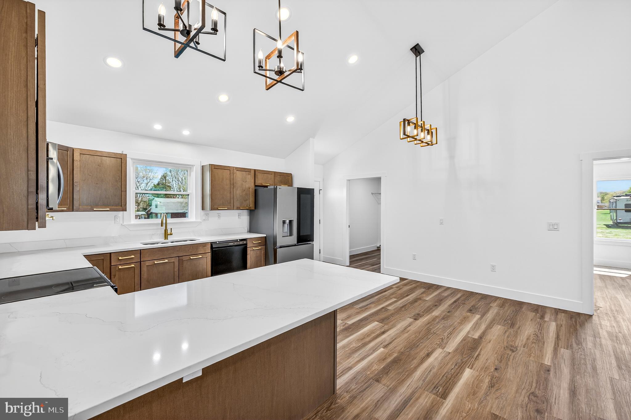 551 Park Road Stanley, VA 22851 - Photo 9 of 83 a large kitchen with stainless steel appliances a large counter top a stove and a chandelier
