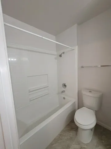 a bathroom with a granite countertop sink toilet and mirror