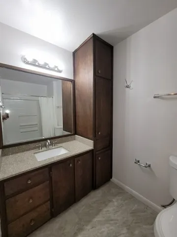 a bathroom with a toilet a sink and mirror