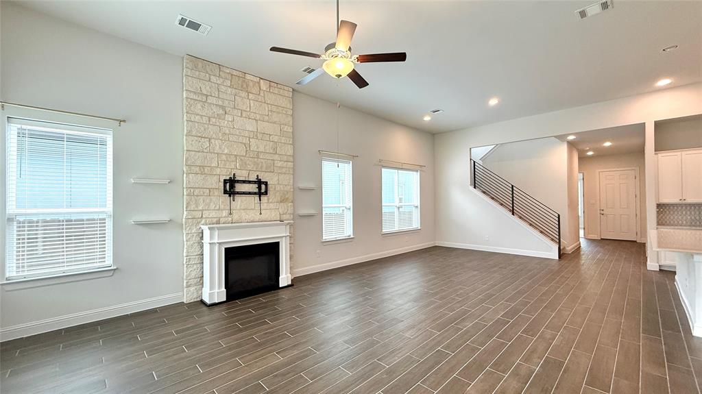 601 C-Bar Ranch Trail, Unit 27 Cedar Park, TX 78613 - Photo 8 of 29 Spacious living area featuring a stone-clad fireplace with mantel, ceiling fan, and recessed lighting