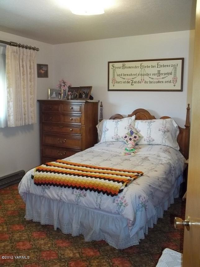 2720 West Wapato Road Wapato, WA 98951 - Photo 14 of 20 a bedroom with a bed and dresser