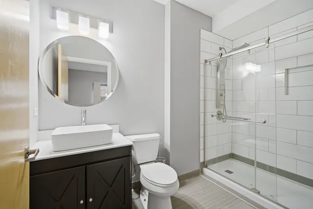 a bathroom with a sink a toilet and shower