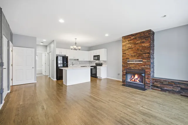 a view of kitchen with kitchen island wooden floor and refrigerator