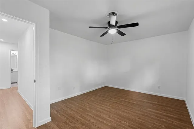 a view of a room with wooden floor cabinets and a ceiling fan