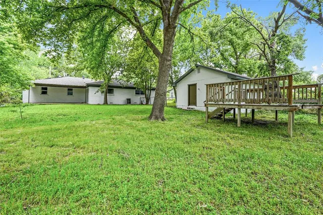 a view of backyard of house with green space