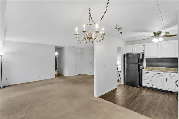 a view of a kitchen with refrigerator and a stove top oven