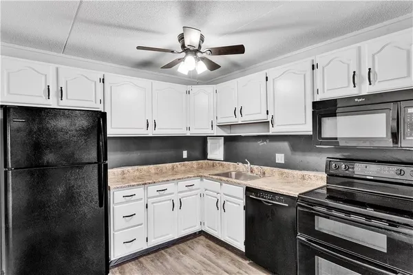 a kitchen with a sink stove and white cabinets