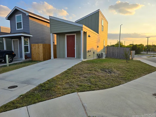 a view of a house with a small yard and wooden fence