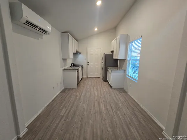 a view of a kitchen with a sink and wooden floor