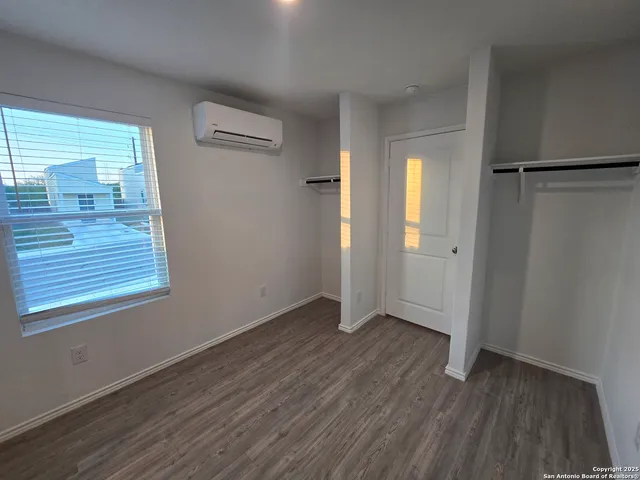an empty room with wooden floor and a window