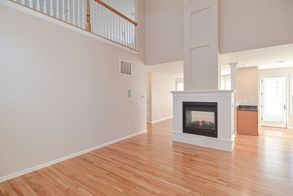 30 Codding Road, Unit 30 Norton, MA 02766 - Photo 14 of 40 a view of an empty room with wooden floor fireplace and a window