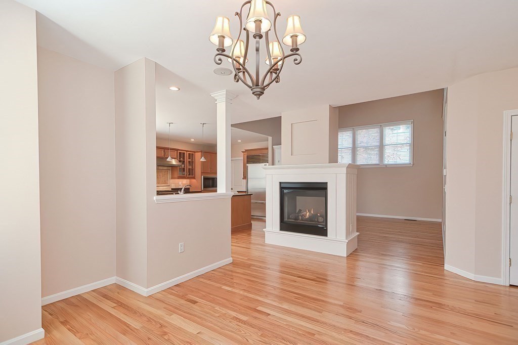 30 Codding Road, Unit 30 Norton, MA 02766 - Photo 15 of 40 a view of a livingroom with wooden floor a fireplace and a window