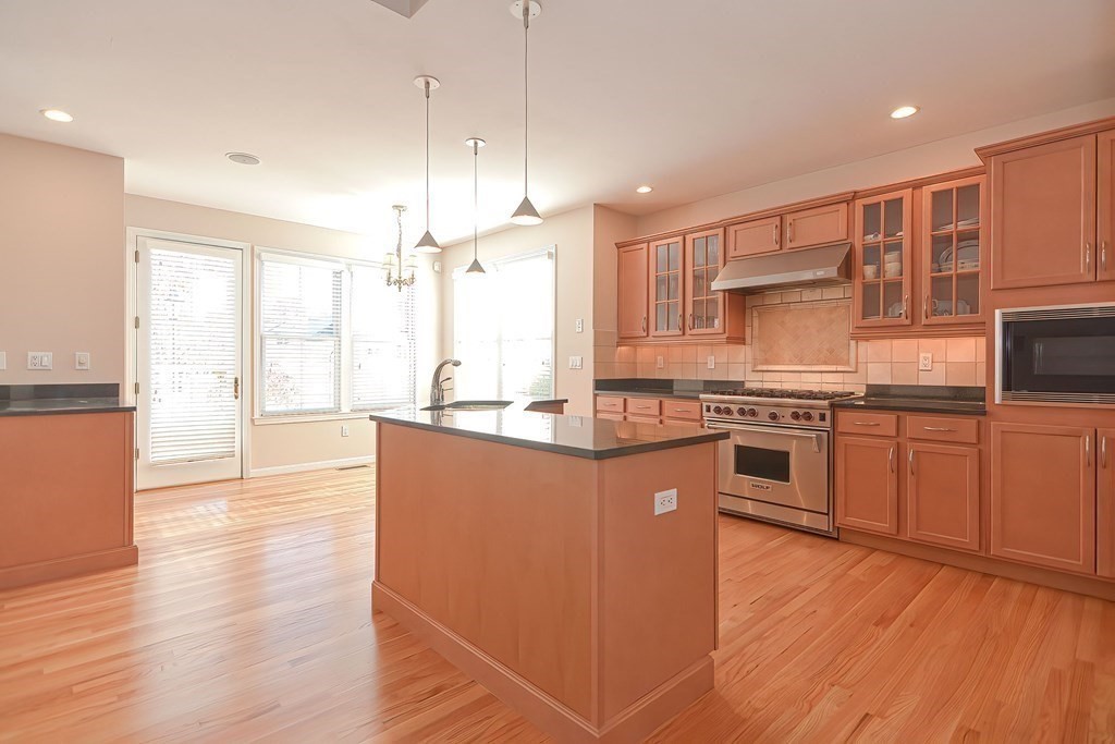 30 Codding Road, Unit 30 Norton, MA 02766 - Photo 7 of 40 a kitchen with stainless steel appliances a refrigerator and wooden floor