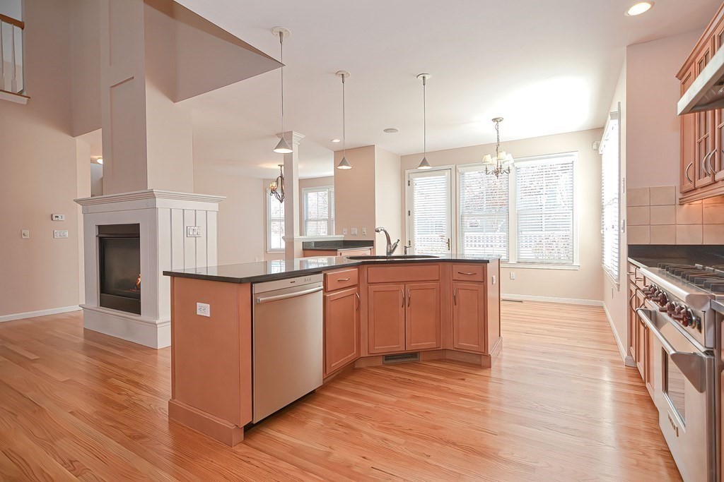 30 Codding Road, Unit 30 Norton, MA 02766 - Photo 9 of 40 a kitchen with stainless steel appliances granite countertop a stove a sink dishwasher and a refrigerator with wooden floor