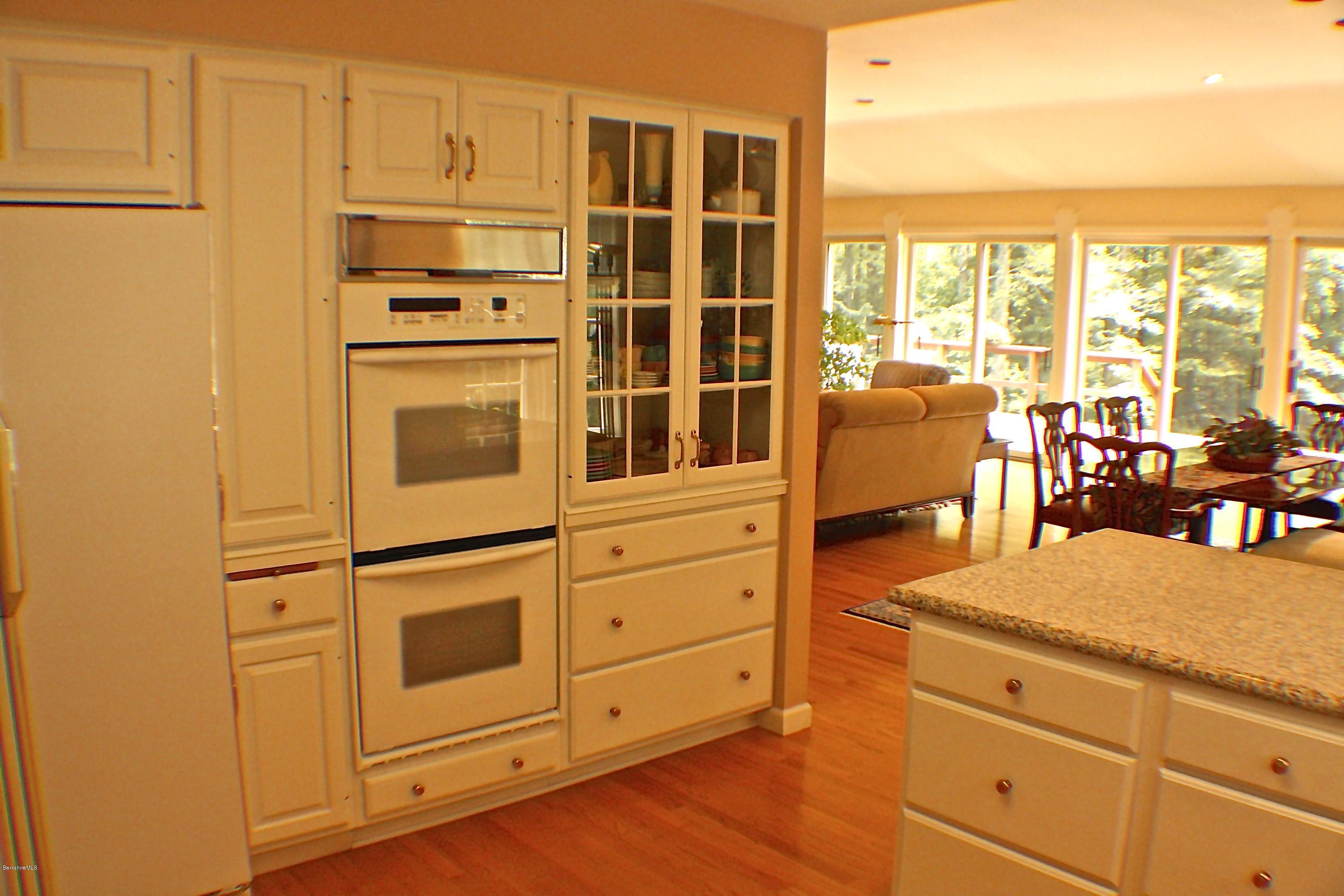 11 Quiet Knoll Road Stockbridge, MA 01266 - Photo 11 of 23 a kitchen with stainless steel appliances granite countertop a stove and white cabinets with wooden floor