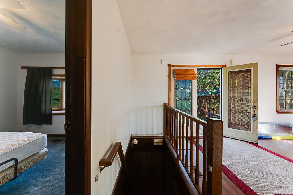 100 Nichols Ridge Road Seaman, OH 45679 - Photo 25 of 43 This interior hallway features a staircase leading to additional living spaces and outdoor access.