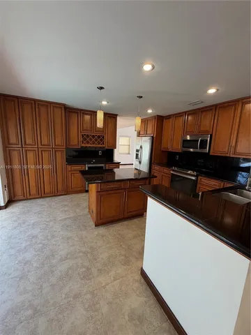 a kitchen with granite countertop a stove and cabinets