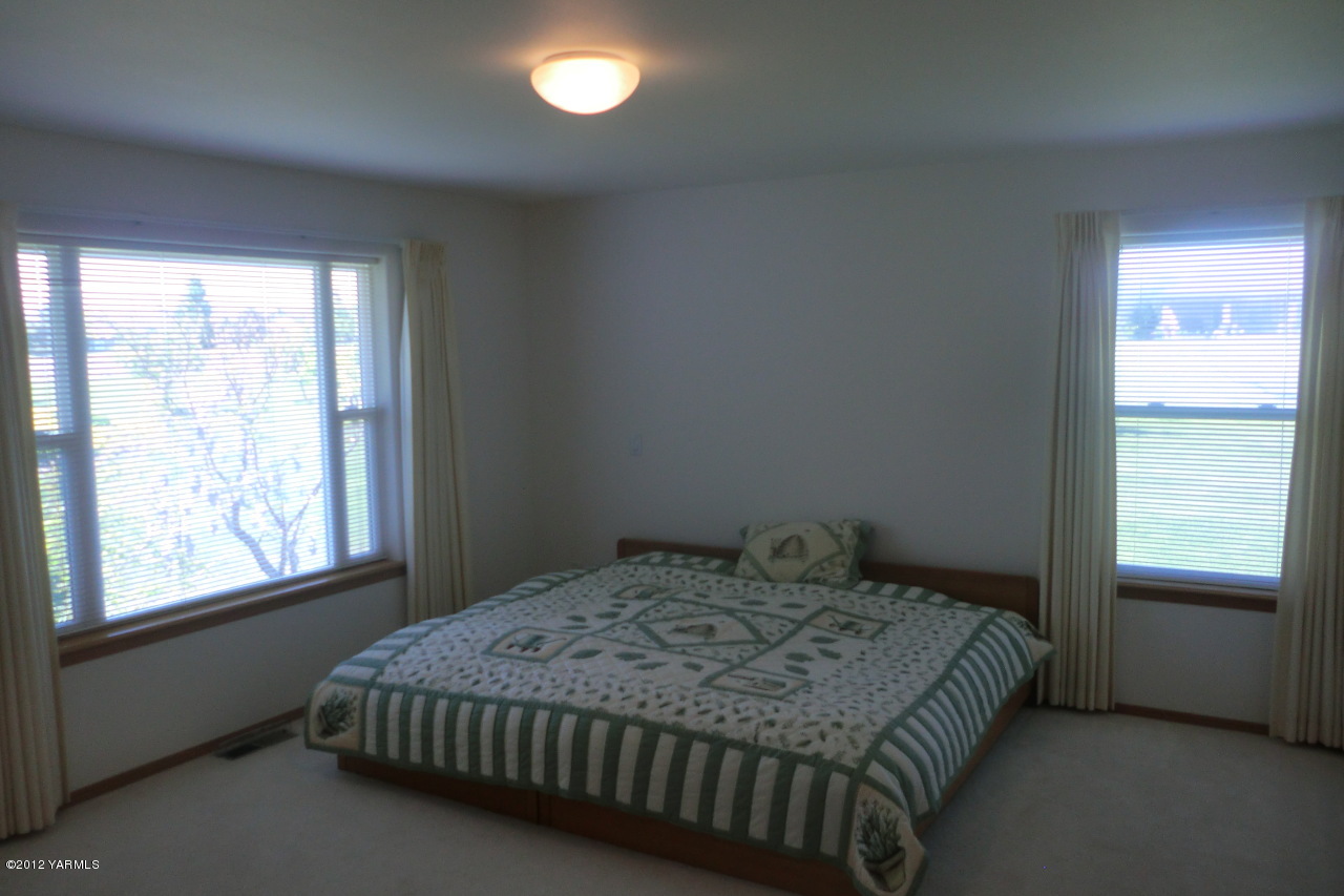 12113 West Barrett Road Yakima, WA 98908 - Photo 17 of 36 a bedroom with a bed and a window