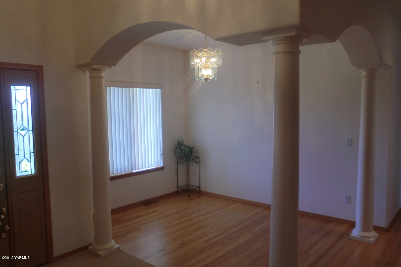 12113 West Barrett Road Yakima, WA 98908 - Photo 4 of 36 an empty room with wooden floor and windows