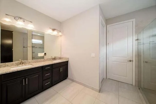 a spacious bathroom with a granite countertop sink mirror and