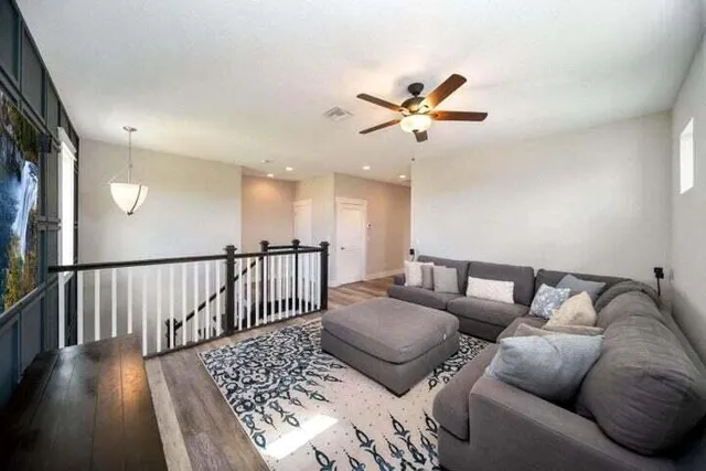 a living room with furniture and a ceiling fan
