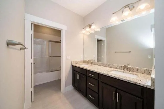 a bathroom with a granite countertop sink double and mirror