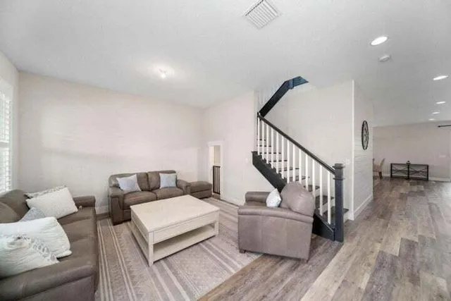 a living room with furniture and wooden floor
