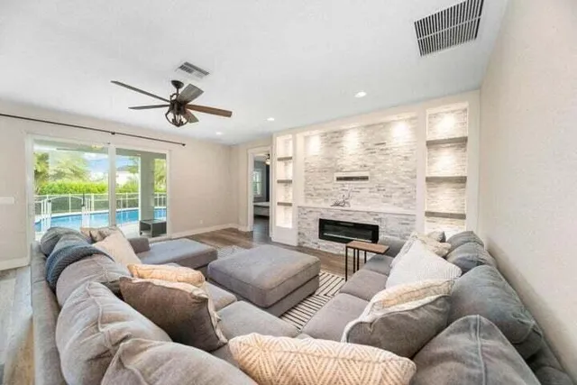 a living room with furniture ceiling fan and a fireplace