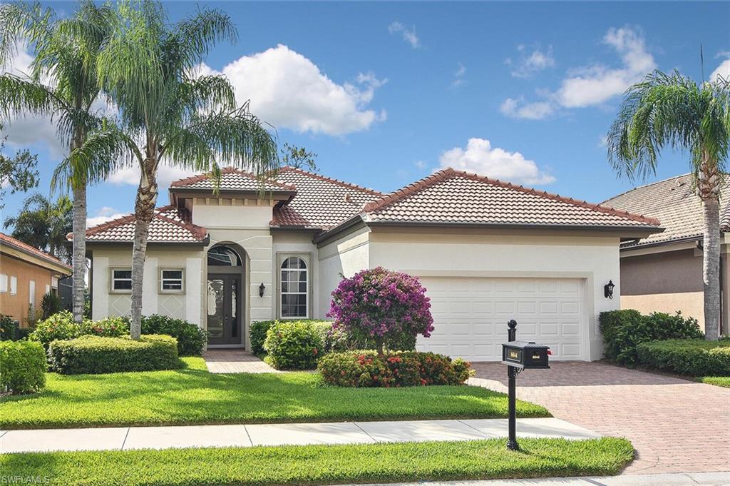 6044 Dogleg Drive Naples, FL 34113 - Photo 1 of 50 a front view of a house with a yard and garage