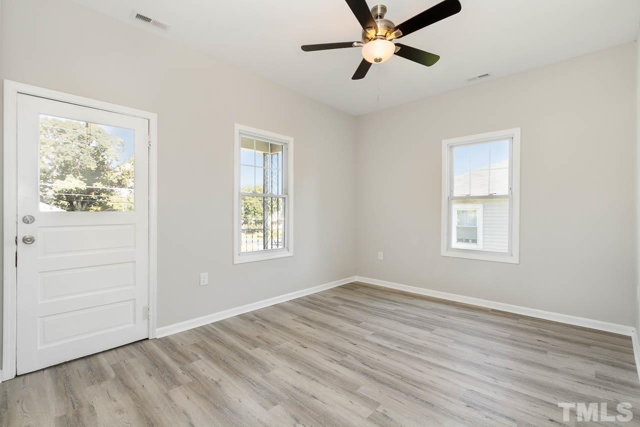 206 Edgar Street Roxboro, NC 27573 - Photo 3 of 18 a view of an empty room with a window and wooden floor
