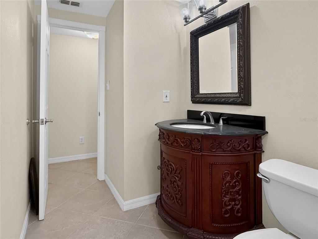 17220 Estes Road Lutz, FL 33548 - Photo 13 of 25 a bathroom with a toilet a sink and mirror
