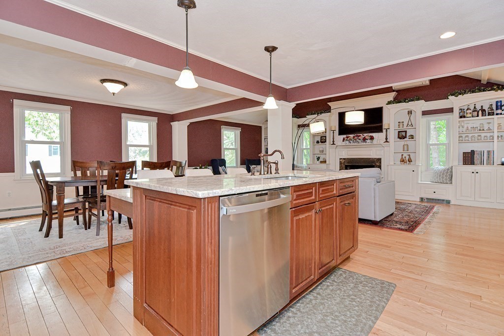1 Ivy Lane Ashland, MA 01721 - Photo 12 of 42 a kitchen with stainless steel appliances kitchen island granite countertop a stove a sink a dining table and chairs