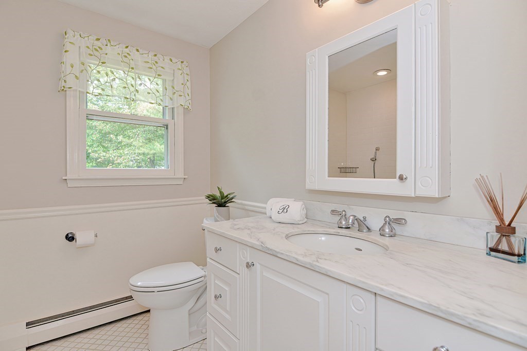 1 Ivy Lane Ashland, MA 01721 - Photo 29 of 42 a bathroom with a granite countertop sink mirror vanity and toilet