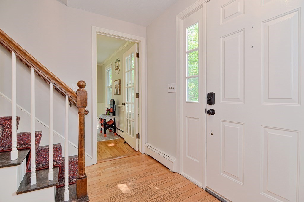 1 Ivy Lane Ashland, MA 01721 - Photo 6 of 42 a view of a hallway with wooden floor and staircase