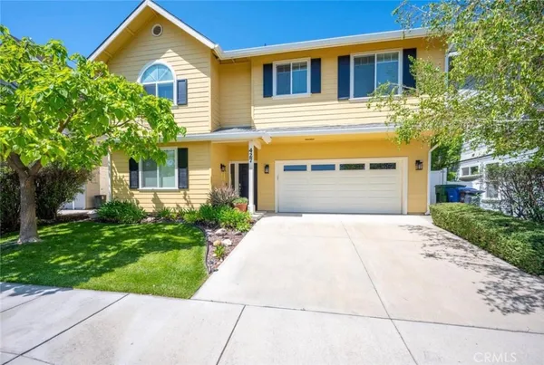 a front view of a house with a yard and a garage