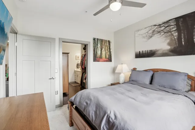 a bedroom with a bed and a painting on the wall