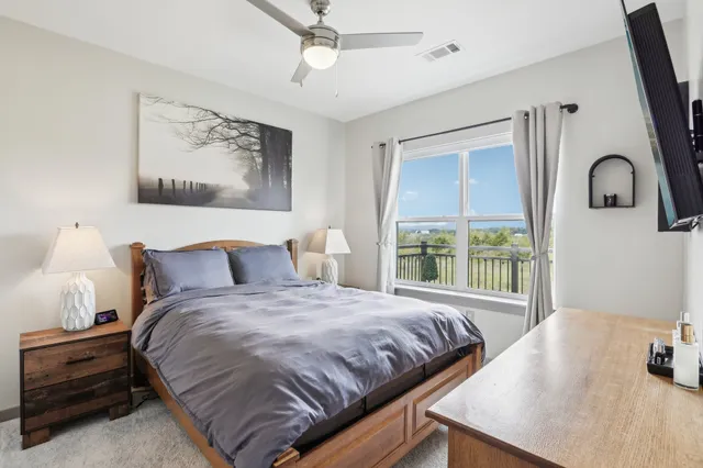 a bedroom with a bed and a large window