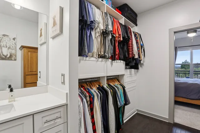 a view of walk in closet with clothes and shoes