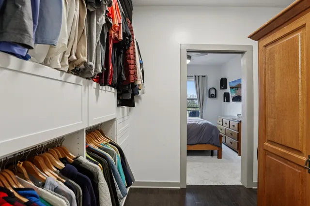 a view of walk in closet with clothes and shoes