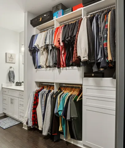 a view of walk in closet with clothes and shoes