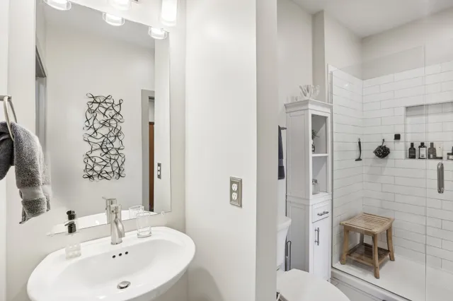 a bathroom with a sink a toilet and shower