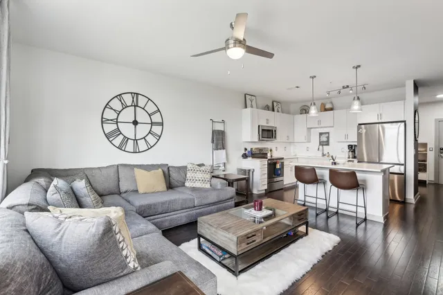 a living room with furniture kitchen view and a chandelier