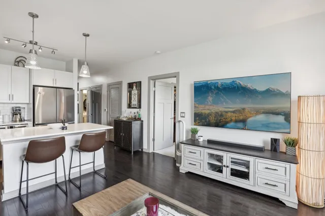 a living room with furniture a flat screen tv and kitchen view