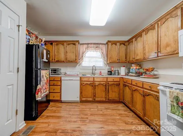 a view of a kitchen with furniture and wooden floor