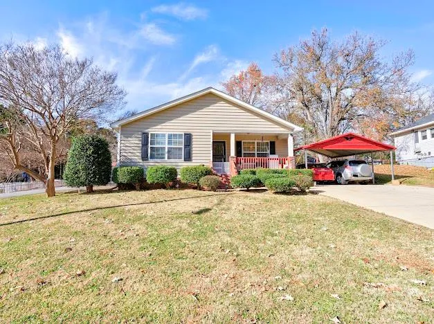 a front view of a house with a yard and trees